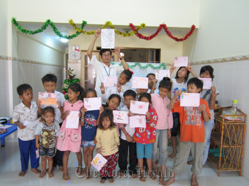Cambodian children show drawings during a class at the Ewha Social Welfare Center. Ewha Womans University