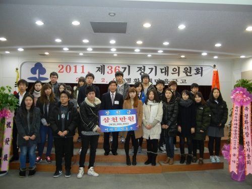 박동주 평화새마을금고 이사장이 시장 상인 자녀 30명에게 장학금을 전달한 후 기념사진을 찍고 있다.