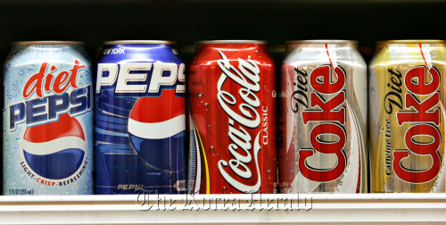 Pepsi and Coca-Cola products sit on display in a New York supermarket.  Bloomberg