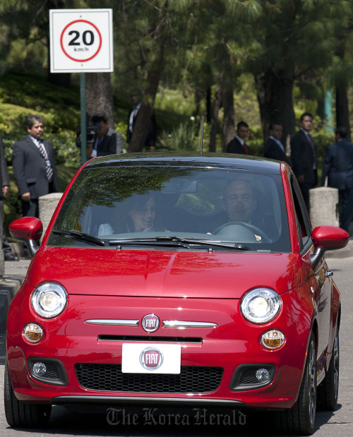 Felipe Calderon (right), president of Mexico, drives the Fiat SpA 500 model vehicle at an event in Mexico City.  Bloomberg