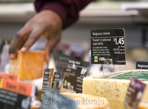 A customer selects a cheese at the delicatessen counter of a supermarket in London.  Bloomberg