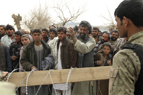 <YONHAP PHOTO-0332> An Afghan soldier speaks to civilians gathered outside a military base in Panjwai, Kandahar province south of Kabul, Afghanistan, Sunday, March 11, 2012. Afghan President Hamid Karzai says a U.S. service member has killed more than a dozen people in a shooting including nine children and three women. Karzai called the attack Sunday "an assassination" and demanded an explanation from the United States. He says several people were also wounded in the attack on two villages near a U.S. base in the southern province of Kandahar. (AP Photo/Allauddin Khan)/2012-03-12 09:38:54/ <저작권자 ⓒ 1980-2012 ㈜연합뉴스. 무단 전재 재배포 금지.>
An Afghan soldier speaks to civilians gathered outside a military base in Panjwai, Kandahar province south of Kabul, Sunday.  AP-Yonhap News