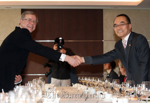 Finance Minister Bahk Jae-wan (right)  shakes hands with EU Ambassador Thomas Kozlowski before having a luncheon meeting with ambassadors from EU member states  in Seoul on Monday.  Yonhap News