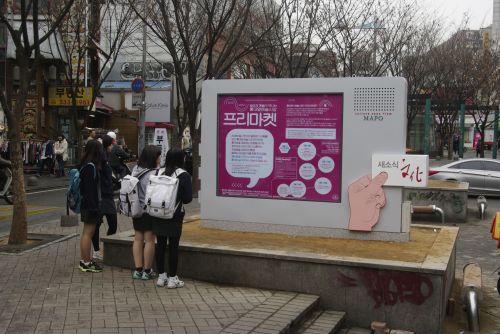 13일 오후 여고생들이 홍대 앞 걷고싶은거리에 설치된 문화예술 전용 게시판에서 볼 만한 공연을 찾고 있다. 서울 마포구는 서교동 걷고싶은거리와 옛 청기와주유소 맞은편 두 곳에 거리공연 등을 알려주는 문화예술 전용 게시판을 설치했다.  [사진제공=마포구청]