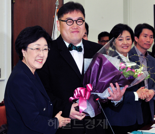 한명숙 민주통합당 대표가 14일 오전 서울 여의도 국회에서 열린 최고위원회의에서 4.11 총선 서울 노원갑에 출마하는 김용민 시사평론가를 소개하고 있다. 박현구 기자phko@heraldm.om 2012.03.14
Democratic United Party chairwoman Han Myeong-sook (left) presents a bouquet to Kim Yong-min during a meeting of party leaders at the National Assembly in Seoul on Wednesday. Park Hyun-koo/The Korea Herald