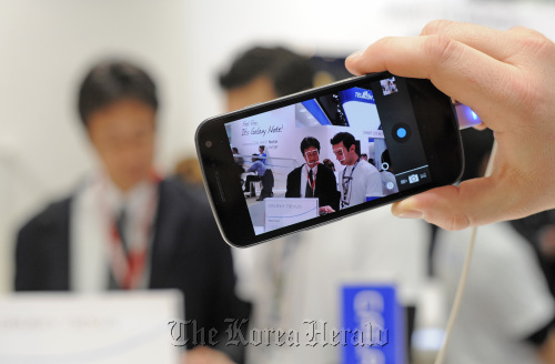 A visitor tests the camera function of a Samsung Electronics Co. Galaxy Nexus smartphone at the Mobile World Congress in Barcelona, Spain, on Feb. 29.  Bloomberg
