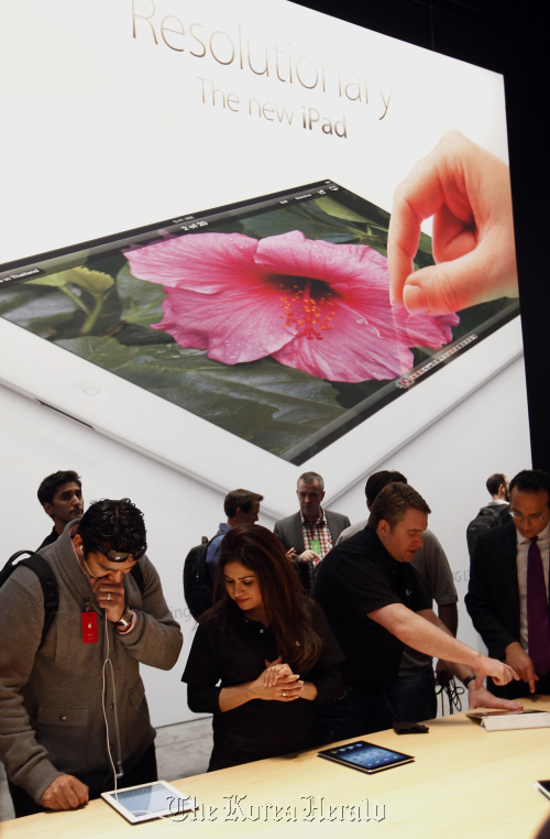 Attendees and members of the media view Apple Inc.’s new version of the iPad tablet computer after its unveiling at an Apple event in San Francisco, California, U.S., on March 7.    Bloomberg