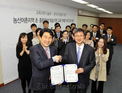 Education Minister Lee Ju-ho (left) and Chung Mong-koo Foundation chairman Yoo Young-hak shake hands after signing an agreement to foster education donations and support students living in the country’s rural areas at a ceremony on Thursday in Seoul.  Hyundai Motor Group