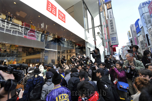Members of the media crowd round the entrance as the first group of customers enter Fast Retailing Co.’s Uniqlo store in the Ginza district of Tokyo on Friday.  Bloomberg
