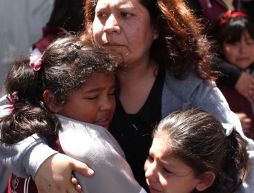 A woman comforts her children outside a school at the Roma neighborhood after a earthquake felt in Mexico City, Tuesday. (AP-Yonhap News)