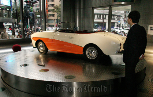 Customers look at an old Nissan “Datsun Sport S211” car at in a Nissan Motor Co. showroom in Tokyo.  Bloombeg