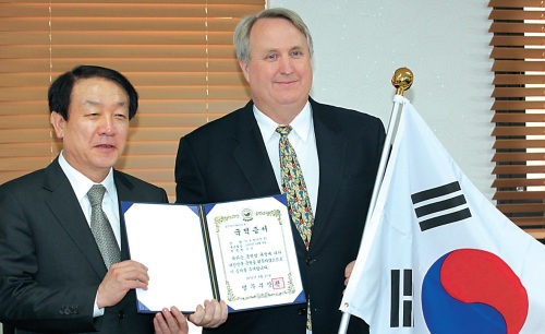 John Linton (right), director of Severance Hospital International
Health Care Center, poses for a photo with the Justice Minister
Kwon Jae-jin, holding his Korean citizenship, in the ministry building
in Gwacheon, Gyeonggi Province, Wednesday. (Yonhap News)