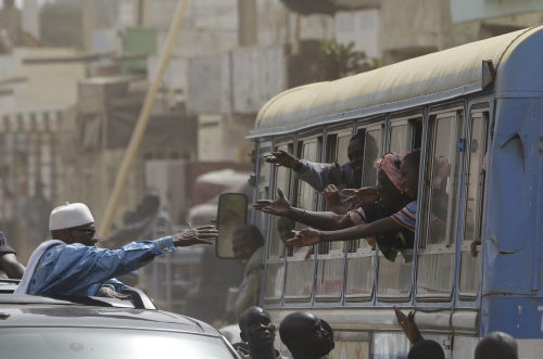 <YONHAP PHOTO-0716> Senegalese President Abdoulaye Wade, left, reaches out toward the arms of supporters passing in a public transit bus as he tours downtrodden suburban areas on the outskirts of Dakar, Senegal, Wednesday, March 21, 2012, days ahead of Senegal's presidential run-off election. Senegal's aging leader will face his former protege Macky Sall in a runoff election on Sunday, March 25. Opposition leaders have united behind Sall in an effort to put an end to Wade's bid for a controversial third term as president. (AP Photo/Rebecca Blackwell)/2012-03-22 10:21:56/ <저작권자 ⓒ 1980-2012 ㈜연합뉴스. 무단 전재 재배포 금지.>
Senegalese President Abdoulaye Wade (left) reaches out toward the arms of supporters passing in a public transit bus as he tours downtrodden suburban areas on the outskirts of Dakar, Senegal, Wednesday.  AP-Yonhap News
