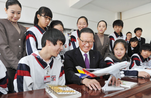 Asiana Airlines chief executive Yoon Young-doo (center) speaks about how an airplane operates to students at a middle school in Tumen, China, on Thursday after donating books to the school.   Asiana Airlines
