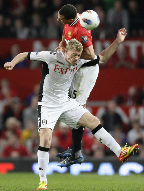 <YONHAP PHOTO-0155> Manchester United's Rio Ferdinand, top, jumps for the ball against Fulham's Pavel Pogrebnyak during their English Premier League soccer match at Old Trafford Stadium, Manchester, England, Monday, March 26, 2012. (AP Photo/Jon Super)/2012-03-27 07:00:16/ <저작권자 ⓒ 1980-2012 ㈜연합뉴스. 무단 전재 재배포 금지.>