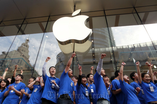 Apple Inc. employees cheer at the official opening of the company’s new store in Shanghai.  Bloomberg