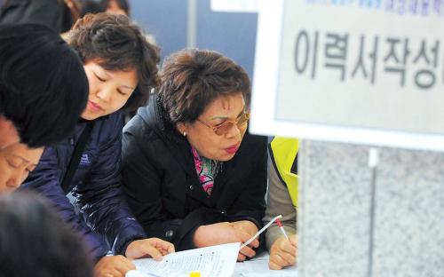 A middle-aged job-seeker writes her resume at a job fair in Seoul for women trying to reenter the workforce. (Lee Sang-sub/The Korea Herald)