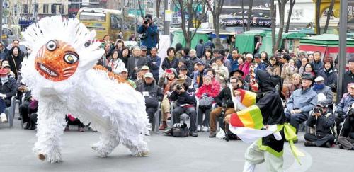 Spectators watch a Bongsan Mask Dance performance in Insa-dong on Tuesday. (Kim Myung-sub/The Korea Herald)