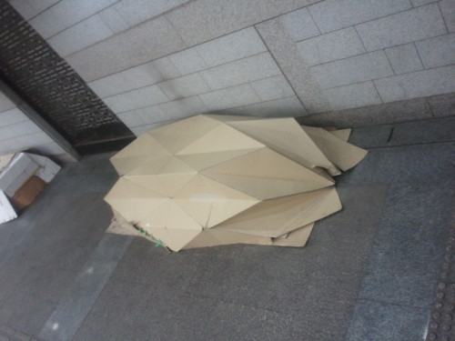 이 곳을 지나던 행인들은 이상하게 생긴 노숙자 박스 텐트를 보면서 휴대폰으로 사진을 찍고 놀라움을 표시하고 있다.