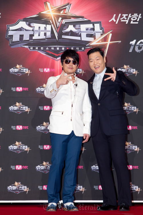 Superstar K4 judges Lee Seung-chul (left) and Psy pose for photo CJ E&M