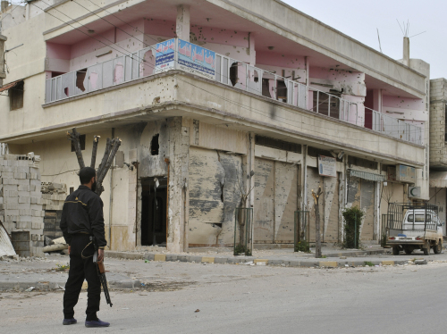 <YONHAP PHOTO-1244> In this picture taken on Sunday March 25, 2012, a Syrian rebel stands guard in front of a damaged building, at Khaldiyeh neighborhoods in Homs province, central Syria. Syrian forces have fired shells at a central city that has come to symbolize the anti-government uprising, activists said, while the country's Muslim Brotherhood branch said it would work for a democratic state if President Bashar Assad falls. (AP Photo)/2012-03-27 17:36:01/ <저작권자 ⓒ 1980-2012 ㈜연합뉴스. 무단 전재 재배포 금지.>
Syrian rebel stands guard in front of a damaged building, at Khaldiyeh neighborhoods in Homs province, central Syria.  AP-Yonhap News