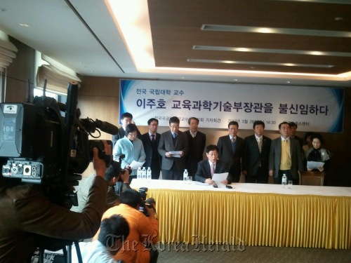 Lee Byung-woon (seated), professor at Pusan National University, announces at a news conference last Wednesday in Seoul that the Korea Federation of National University Professor Associtions passed no-confidence vote against Education Minister Lee Ju-ho. Korea Federation of National University Professor Associations