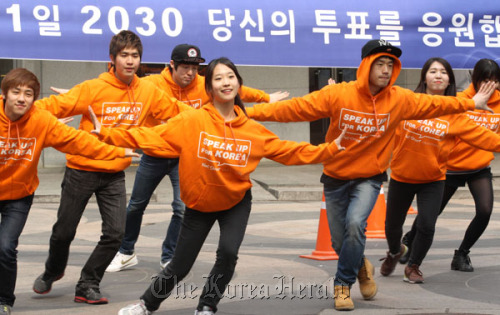 College students put on a dance performance during a recent street campaign to encourage young people to participate in the parliamentary election at Myeongdong, central Seoul.  Yonhap News