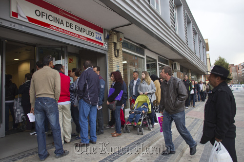 Job-seekers wait outside a job center before opening in Madrid on Monday.  Bloomberg