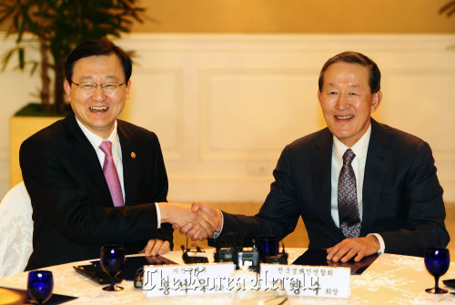 Knowledge Economy Minister Hong Suk-woo (left) shakes hands with FKI chief Huh Chang-soo during their meeting at a Seoul hotel on Tuesday.      MKE
Knowledge Economy Minister Hong Suk-woo (left) shakes hands with FKI chief Huh Chang-soo during their meeting at a Seoul hotel on Tuesday.      MKE