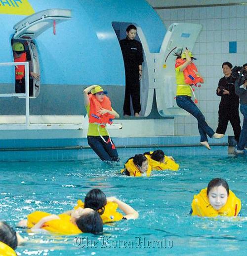 Newly recruited flight attendants at Jin Air receive training on how
to cope with an emergency in western Seoul on Wednesday .
(Kim Myung-sub/The Korea Herald)