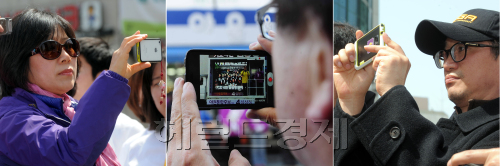 제19대 총선날인 4월 11일이 5일 앞으로 다가온 가운데 각 지역구마다 선거운동이 절정에 다다르고 있다. 가는 길을 멈추고 선거유세를 지켜보는 유권자들이 스마트폰 등으로 유세현장을 담고 있다./ 안훈기자 rosedale@ 2012.04.05
제19대 총선날인 4월 11일이 5일 앞으로 다가온 가운데 각 지역구마다 선거운동이 절정에 다다르고 있다. 가는 길을 멈추고 선거유세를 지켜보는 유권자들이 스마트폰 등으로 유세현장을 담고 있다./ 안훈기자 rosedale@ 2012.04.05
유세장도 스마트폰이 대세. 4ㆍ11총선이 5일 앞으로 다가온 가운데, 자신이 지지하는 후보들의 유세장면을 스마트폰에 담아 트위터 등 SNS로 전파하는 게 새로운 선거 풍속으로 떠올랐다.  안훈 기자/rosedale@