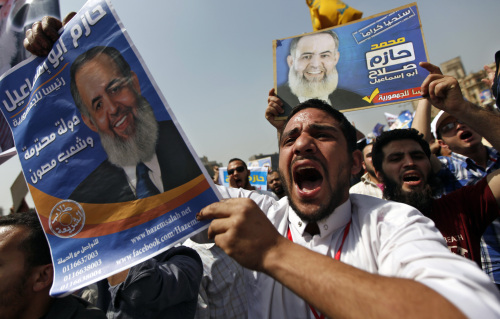 <YONHAP PHOTO-0036> Egyptian protesters chant slogans holding posters of presidential candidate, Hazem Abu Ismail, with Arabic writing reads, " Hazem Abu Ismail is the President of the Republic. Respectable Country, protected people.", during a rally in Tahrir Square in Cairo, Egypt, Friday, April 6, 2012. Thousands rallied in Cairo on Friday in support of an ultraconservative Islamist presidential hopeful who may be disqualified from the race after it was announced that his mother was an American citizen. (AP Photo/Khalil Hamra)/2012-04-07 00:42:55/ <저작권자 ⓒ 1980-2012 ㈜연합뉴스. 무단 전재 재배포 금지.>
Egyptian protesters chant slogans holding posters of presidential candidate, Hazem Abu Ismail, which read, “ Hazem Abu Ismail is the President of the Republic. Respectable Country, protected people,” during a rally in Tahrir Square in Cairo on Friday.  AP-Yonhap News