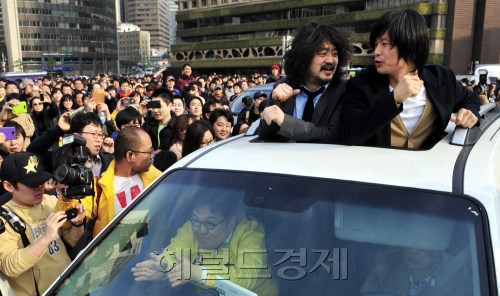 8일 오후 서울광장에서 '나는 꼼수다' 출연진 김용민 민주통합당 노원갑 후보, 주진우 기자, 김어준 총수가 대번개를 갖고 차에서 팬들에게 인사하고 있다.<br />김명섭 기자 msiron@