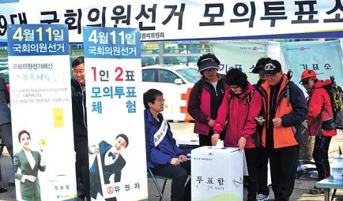 People cast ballots at mock polling booths in Seoul on Sunday during an event organized by the capital’s election watchdog to boost voter participation. (Kim Myung-sub/The Korea Herald)