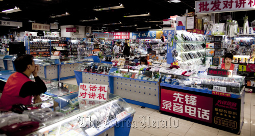 Vendors await customers at a shopping complex in Beijing.  Bloomberg