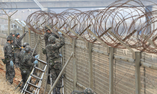 <YONHAP PHOTO-0343> 철거 시작된 김포 한강철책 (인천=연합뉴스) 하사헌 기자 = 군 장병들이 9일 오전 경기도 김포시 전호리에서 김포대교 인근 김포쪽 한강철책 철거작업을 하고 있다. 2012.4.9 toadboy@yna.co.kr/2012-04-09 10:43:44/ <저작권자 ⓒ 1980-2012 ㈜연합뉴스. 무단 전재 재배포 금지.>
Soldiers dismantle the fencing along the southern bank of the Han River in Gimpo on Monday.  Yonhap News