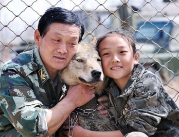 Zhu Yongsheng and his daughter Zhu Lin cuddle a wolf at the family's animal training base in Urumqi, the Xinjiang Uygur autonomous region, on Saturday. (ANN/China Daily)
