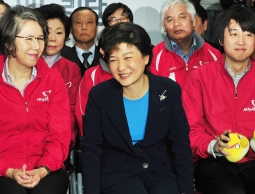 Saenuri Party chief Park Geun-hye (center) smiles while watching the election broadcast at the party’s headquarters in Seoul on Wednesday. (Park Hyun-koo/The Korea Herald)