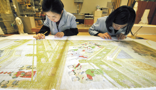 Members of the National Museum of Korea’s conservation team restore a damaged Joseon painting  in their office in Seoul on March 28.   (Kim Myung-sub/The Korea Herald)