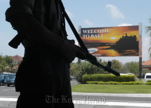 An Indonesian policeman patrols Bali’s international airport.  Bloomberg