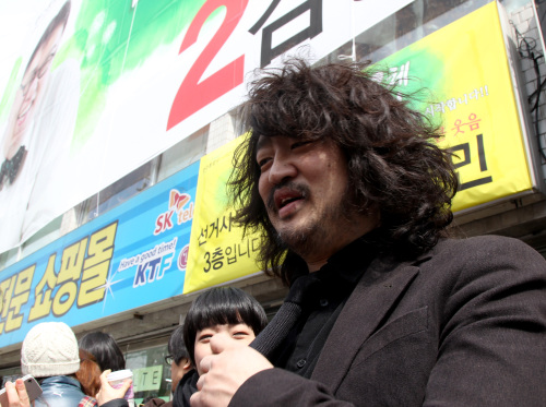 <YONHAP PHOTO-0819> 김어준, 나꼼수 후보 지원 (서울=연합뉴스) 딴지일보 총수 김어준씨가 25일 서울시 노원구 공릉동 나꼼수 멤버 김용민 후보 선거사무소 개소식에 참석, 지지자들과 대화하고 있다. 2012. 3. 25 srbaek@yna.co.kr/2012-03-25 16:13:27/ <저작권자 ⓒ 1980-2012 ㈜연합뉴스. 무단 전재 재배포 금지.>
Kim Eo-jun
