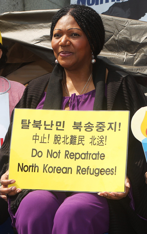 <YONHAP PHOTO-0514> 탈북자 강제 북송 반대 집회장 찾은 리즈 미첼 (서울=연합뉴스) 홍기원 기자 = 그룹 보니엠의 리드싱어 리즈 미첼이 17일 오전 서울 종로구 효자동 중국대사관 맞은편 옥인교회 앞에서 열리고 있는 탈북자 강제 북송 반대 집회장을 방문해 손팻말을 들고 있다. 보니엠은 오는 21일 세종문화회관 대극장에서 내한공연을 펼치며 공연 개런티는 탈북자 지원 단체에 기부 한다. 2012.4.17 xanadu@yna.co.kr/2012-04-17 13:27:30/ <저작권자 ⓒ 1980-2012 ㈜연합뉴스. 무단 전재 재배포 금지.>
Singer Liz Mitchell participates in a rally protesting Beijing’s forcible repatriation of North Korean defectors in front of the Chinese Embassy in Seoul on Tuesday.  Yonhap News