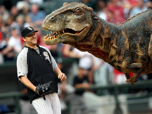 Chicago White Sox pitcher Mark Buerhle has a chuckle with "Baby T Rex" animated figure which threw out the first pitch before the game against the Detroit Tigers at at U.S. Cellular Field in Chicago, Illinois, August 6, 2008.