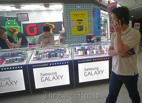 A man walks past a mobile phone store in Seoul.  Bloomberg