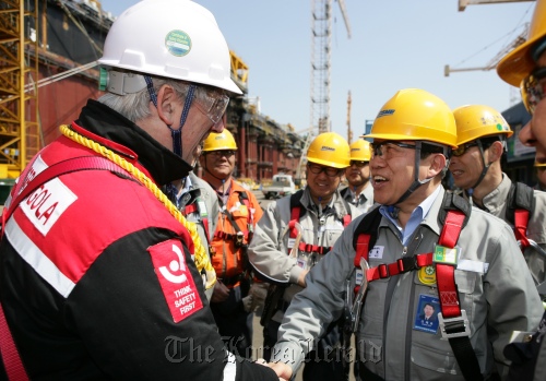DSME CEO Ko Jae-ho (right) shakes hands with Total E&P Angola’s FPSO manager Patrick Vallot during his visit to the shipyard on Geoje Island earlier this month.  DSME