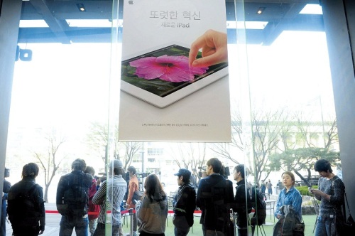 People who pre-ordered wait in line to get Apple’s new iPad outside a store in Seoul on Friday.     (Park Hae-mook/The Korea Herald)