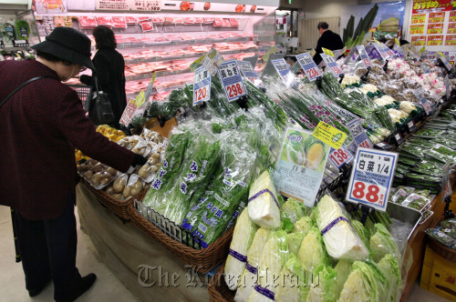 A shopper looks at vegetables in a supermarket in Tokyo.  Bloomberg