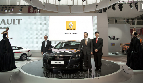 Renault-Nissan chairman and CEO Carlos Ghosn (second from right) poses with the SM7, dubbed Talisman in China, during the Auto China 2012 in Beijing on Monday.  Renault Samsung Motors