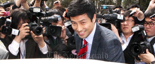 논문표절 의혹으로 자질 논란에 휩싸인 새누리당 문대성 국회의원 당선자가 18일 오후 국회 정론관에서 할 예정이던 기자회견을 취소하고 돌아가다 급히 쫒아간 기자들에게 입장을 설명한 뒤 승용차에 오르고 있다.<br />박현구 기자/phko@heraldm.com 120418
Moon Dae-sung, a lawmaker-elect, gets into his car near the National Assembly building last Wednesday, shortly after canceling a news conference on his thesis plagiarism.  Park Hyun-koo/The Korea Herald