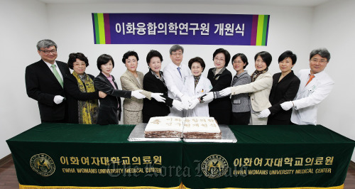 Ewha Womans University Medical Center head Suh Hyun-suk (seventh from left), Ewha Medical Collaboration Research Center chief Kim Seung-cheol (sixth from left) and others pose at the research center’s opening ceremony on Monday in Seoul.  EWUMC